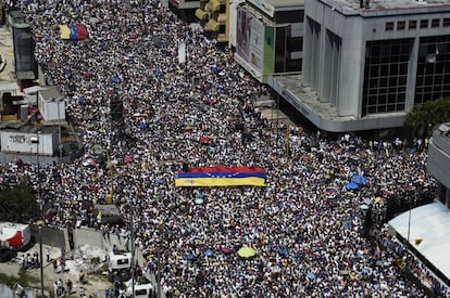 Una bandera de Venezuela es porteada por los manifestantes opositores en las calles de Caracas.