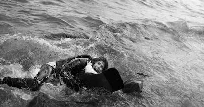 Una madre abrazada a su hijo en el agua en la costa de Lesbos.