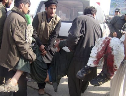 Varias personas transportan a v&iacute;ctimas del atentado en Kabul. 