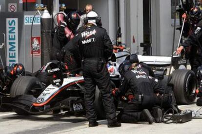 Los mecánicos trabajan en el dañado McLaren de Raikkonen.