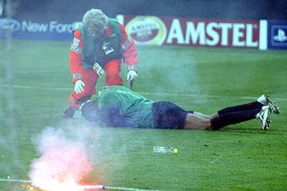 El portero del Milan, Dida, cae al suelo tras recibir el impacto de una bengala.