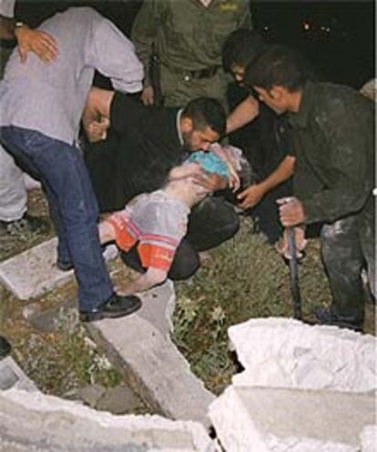 Los equipos de rescate palestinos, junto al cadáver de la niña de ocho años que ha resultado muerta tras la explosión.
