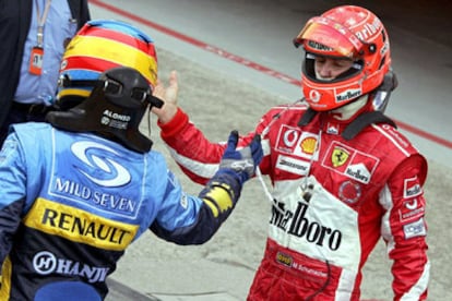 Fernando Alonso y Michael Schumacher se saludan al término de su duelo.