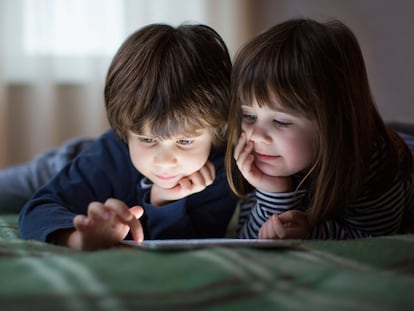 Dos niños juegan con su tableta.