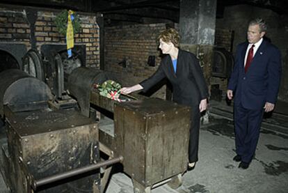 George W. Bush y su esposa, Laura, quien coloca una rosa en un horno usado para incinerar prisioneros en el campo de exterminio de Auschwitz.