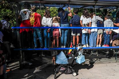 El público se agolpa en una parada de autobús para seguir el desfile del 12 de octubre.