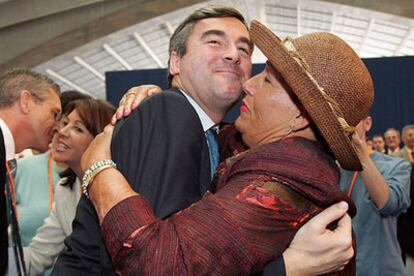 Ángel Acebes recibe un abrazo de una de las asistentes al congreso regional del PP en Santa Cruz de Tenerife.
