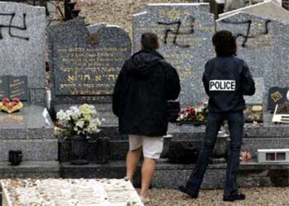 Agentes de policía inspeccionan las tumbas profanadas en el cementerio judío de Gerland, Lyón.