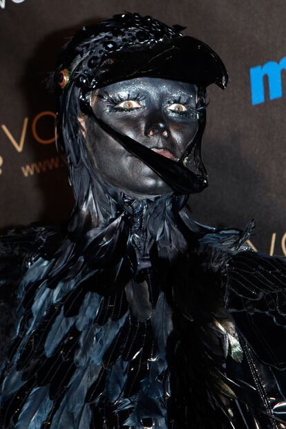 Con toda la cara pintada de negro, la modelo escondió su melena rubia bajo el disfraz de plumas. 