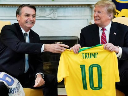 Bolsonaro entrega uma camisa da seleção brasileira a Trump na Casa Branca.