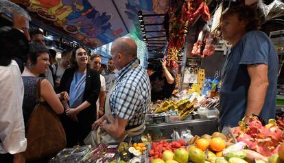 Ada Colau conversa ayer con un tendero de La Boqueria.