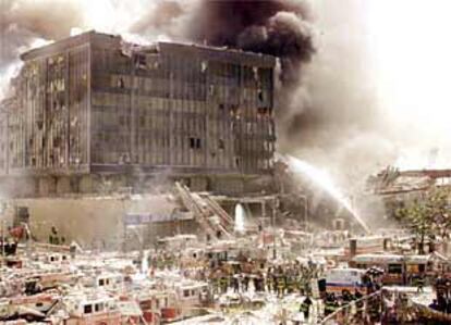 Grupos de bomberos intentan sofocar el fuego en los restos del World Trade Center de Nueva York tras los ataques con dos aviones secuestrados.