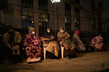 La gente espera envuelta en mantas frente a un hospital para recibir la vacuna contra la covid-19, en Cochabamba, Bolivia, el 8 de junio.