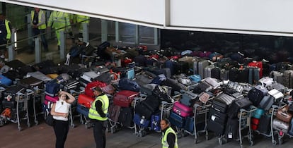 Operarios de Londres-Heathrow ante centenares de maletas perdidas el lunes.