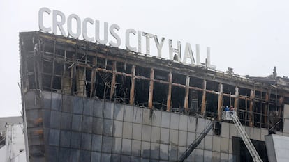 Personal de emergencias trabajan con una grúa en el exterior de la sala de conciertos Crocus, este sábado. 