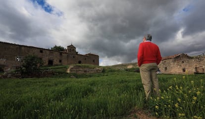 Una persona, frente a la iglesia en mitad de la plaza de Coto de Lomeda.