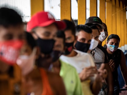 Pessoas fazem fila para votar no único centro eleitoral da comunidade Lago do Catalão, na zona rural de Iranduba, no Amazonas. No Lago do Catalão, onde todas as casas ficam na água, os eleitores vão de barco para votar na escola da comunidade.