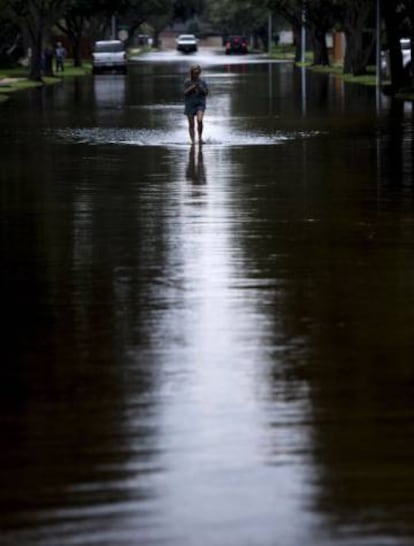 Una mujer recorre una calle en Houston inundada por Harvey.