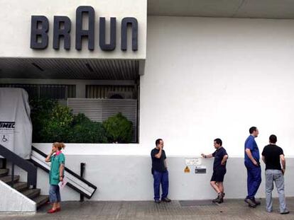 Varios operarios de Braun ayer, ante la entrada de la planta de la empresa en Esplugues de Llobregat.