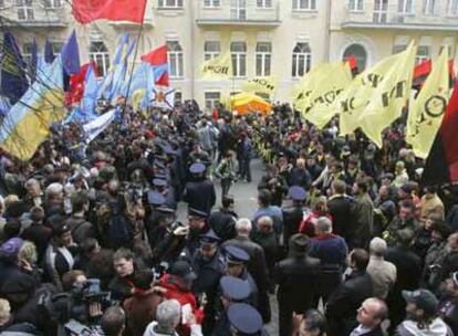 La policía separa a los partidarios del primer ministro, Víktor Yanukóvich (izquierda), de los seguidores del presidente, Yúshenko, ayer en el centro de Kiev.