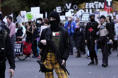 Una mujer armada asiste a una protesta a favor de que se cuente hasta el último voto, en Portland. 