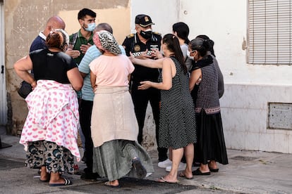Un policía conversa con los vecinos afectados por el desalojo en Valencia, un miembro del Sindicato Construimos Malilla y un trabajador social. 