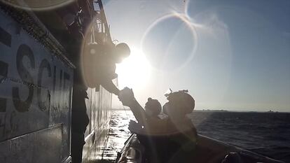 Un rescatista de la ONG española Open Arms ayuda a un migrante a subir a un bote en el mar Mediterráneo el 14 de noviembre de 2020.