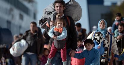 Grupos de refugiados caminan a trav&eacute;s del puerto de Pireo, despu&eacute;s de llegar de las islas griegas de Lesbos y Qu&iacute;os desde Turqu&iacute;a