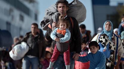 Grupos de refugiados caminan a trav&eacute;s del puerto de Pireo, despu&eacute;s de llegar de las islas griegas de Lesbos y Qu&iacute;os desde Turqu&iacute;a