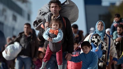 Grupos de refugiados caminan a trav&eacute;s del puerto de Pireo, despu&eacute;s de llegar de las islas griegas de Lesbos y Qu&iacute;os desde Turqu&iacute;a