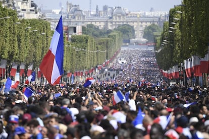 Miles de personas esperan la llegada de la selección francesa de fútbol en los Campos Elíseos para celebrar el Mundial de fútbol. 