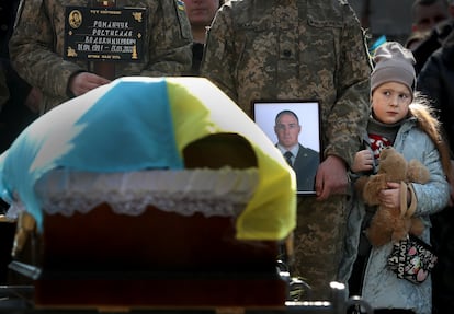 El 16 de marzo enterraron a 4 de los 35 militares muertos en el ataque ruso a la base ucraniana de Yavoriv. La hija de Volodimir Romanchuk, militar de 31 años, se abraza a un peluche y mira el féretro con los restos mortales de su padre, en el cementerio de Lychakiv, en Lviv, Ucrania. 