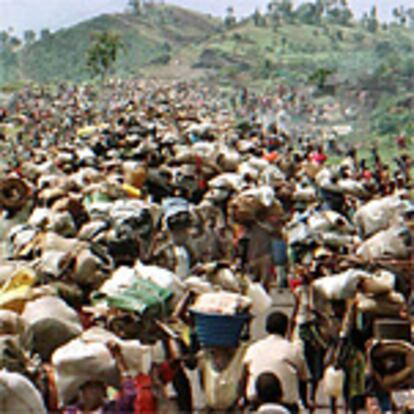 Una multitud sin fin de refugiados camina con sus pertrechos a cuestas hacia la frontera, de vuelta a sus hogares en Ruanda