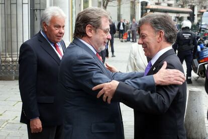 Juan Luis Cebrián recibe al presidente de Colombia, Juan Manuel Santos, en presencia de Felipe González, a su llegada al Teatro Real de Madrid, donde han participado en el Foro por la paz en Colombia, organizado por EL PAÍS.