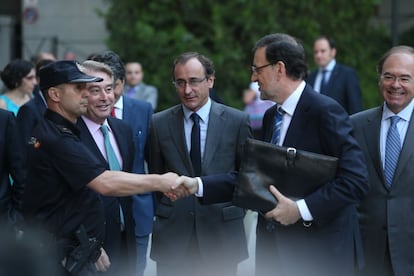 Mariano Rajoy saluda a uno de los agentes que hacen guardia en el edificio del Senado en Madrid, junto al portavoz del Grupo Popular, Alfonso Alonso, y el presidente de la Cámara alta, Pío García Escudero.