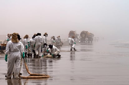 Cuadrillas de limpieza trabajan para remover petróleo de la playa Cavero en Callao, Perú, el 26 de enero de 2022, luego de un derrame ocurrido durante el proceso de descarga del buque tanque de bandera italiana "Mare Doricum" en la refinería La Pampilla.