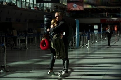 Una pareja se abraza en el aeropuerto internacional de Ezeiza, en Buenos Aires, antes de embarcar hacia Alemania, el 23 de marzo.