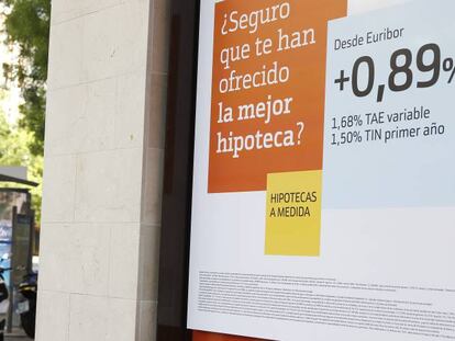 Dos personas pasan junto a un anuncio hipotecario en Madrid.