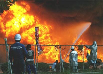 Varios bomberos combaten el fuego en la planta japonesa de Bridgestone.