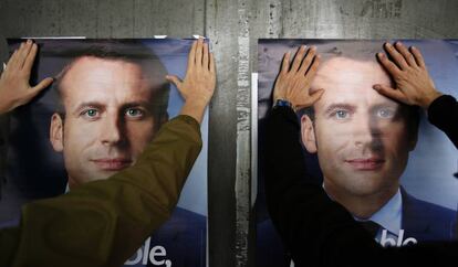 Un simpatizante de Macron pega un cartel electoral este martes en Lille.