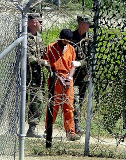 Dos guardias trasladan a un detenido en la prisión de la base de Guantánamo para ser interrogado.