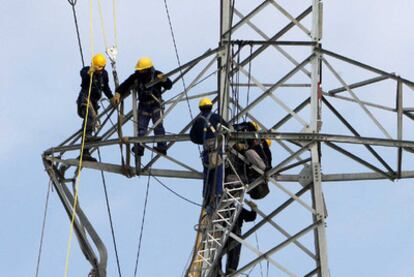 Varios operarios reparan una torre de tendido eléctrico en Girona.