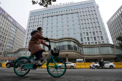 Un ciclista pasa junto al hotel donde un equipo de expertos de la Organización Mundial de la Salud está en cuarentena en Wuhan este jueves.