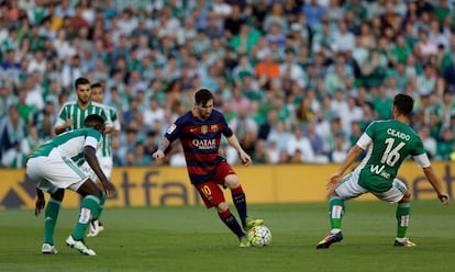 Leo Messi controla la pilota davant de dos jugadors del Betis.