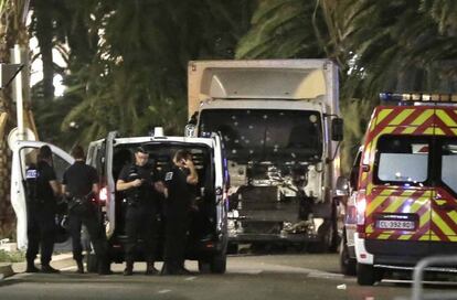 Policías permanecen junto al camión que arremetió contra una multitud que presenciaba los fuegos artificiales de la Fiesta Nacional del 14 de julio en Niza. Decenas de personas han muerto.