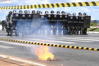 Unos antidisturbios se protegen con sus escudos.