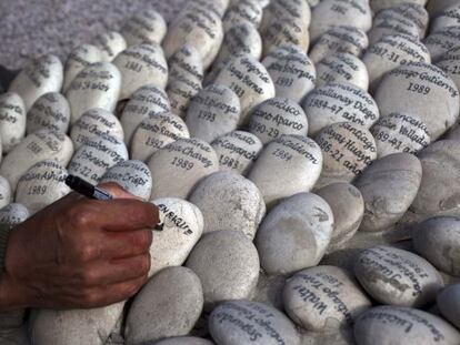 Simeon Irrazabal writes the name of his father, who he said was killed by the Peruvian army in 1987, at the &quot;Ojo que Llora&quot; or &quot;Eye that Cries&quot; memorial in Lima, Peru, Wednesday, Aug. 28, 2013. 