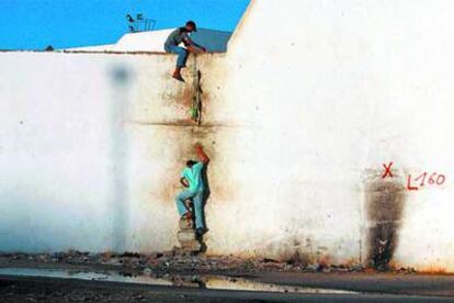 Dos niños marroquíes escalan uno de los muros para acceder clandestinamente al puerto de Tánger.