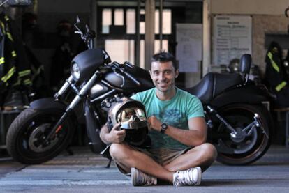 Óscar Vega posa delante de su moto pero con el casco de bombero. "Europa no hubiera soportado un terremoto como el de Haití".