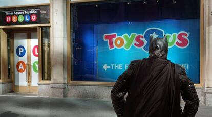 Un hombre disfrazado de Batman observa una tienda de Toys 